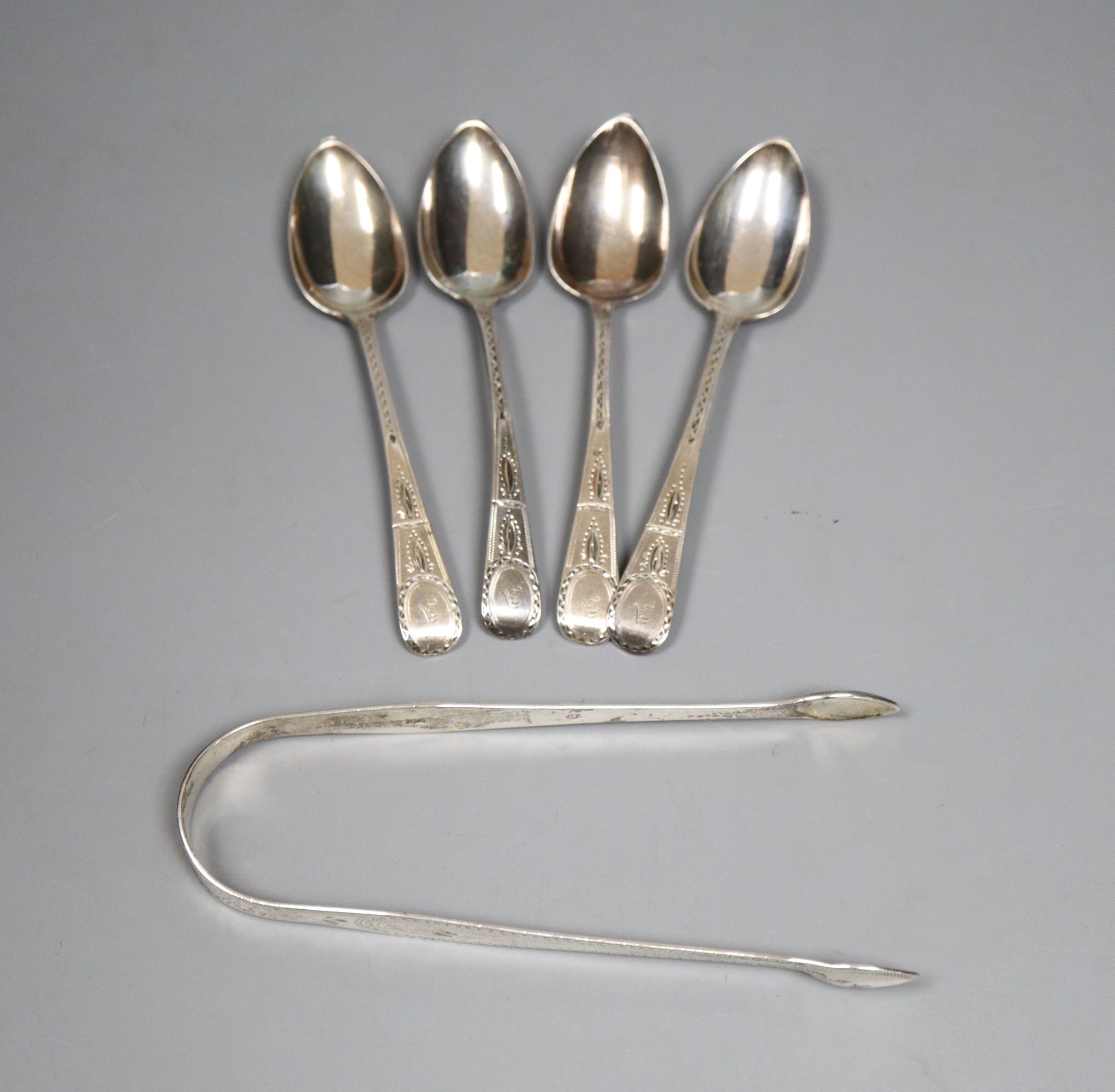A pair of George III silver bright cut sugar tongs, by Hester Bateman and a set of four similar teaspoons, London, 1796